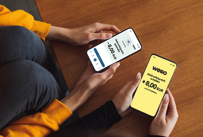 Over the shoulder view, unrecognizable caucasian woman in yellow shirt holding a smart phone with blank screen.