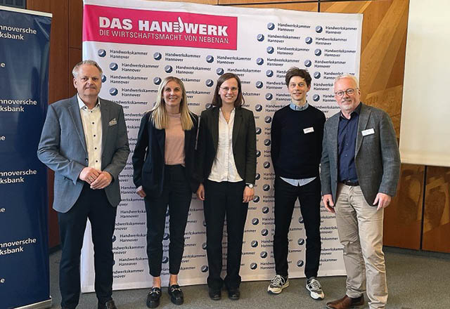 Vor einem gro en Banner der Handwerkskammer Hannover, mit der berschrift „Das Handwerk / Die Wirtschaftsmacht. Von nebenan.“stehen f nf l chelnde Personen in leger-gesch ftlicher Kleidung.  Foto: Hannoversche Volksbank